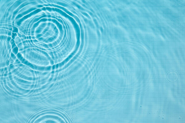 Gentle ripples on a clear blue pool surface, creating a calming and serene atmosphere.