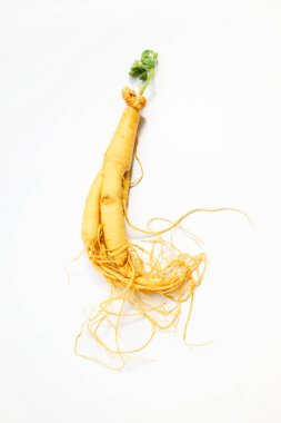Beyaz arka planda yeşil yapraklı taze bir ginseng kökü. Canlı ve organik..