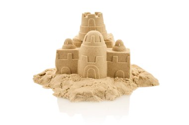 Beyaz zemin üzerinde ayrıntılı bir kumdan kale heykeli. Karmaşık kuleler ve duvarlar sergileniyor..