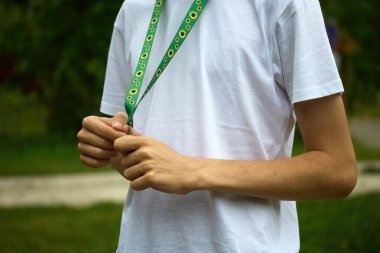 Ayçiçeği kordonu, görünmez ya da gizli engelli insanların sembolü. Beyaz gömlek giyen biri yeşil ipli kemancı, ayçiçeği desenli..