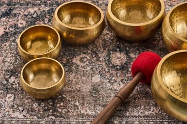 Süslü halıda kırmızı kadife çekiçle pirinçten şarkı söyleyen kaseler. Sıcak, rahatlatıcı bir ortam..