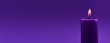 A single purple candle glowing warmly against a minimalist purple background. clipart