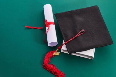 Yeşil arkaplan diploması mezuniyet başarısını simgeliyor..