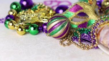 Mardi Gras boncukları ve bebek heykelciğiyle bezenmiş renkli bir Kral Pastası. Canlı yeşil, mor ve altın rengi..