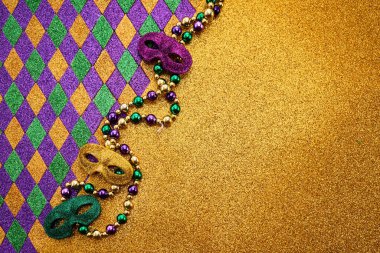 Colorful Mardi Gras masks on glittering gold with beads. clipart