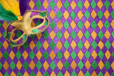 Canlı bir Mardi Gras maskesi pırlanta desenli arka planda yatıyor..