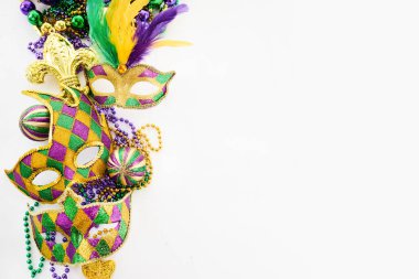 Beyaz arka planda canlı Mardi Gras maskeleri ve boncukları.