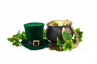 A green hat, black cauldron of gold coins, horse shoe, and shamrocks symbolize St. Patricks Day traditions. clipart