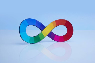 Mavi arkaplana karşı yansıtıcı yüzeyde renkli bir sonsuzluk sembolü.