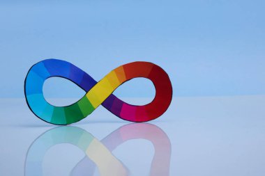 Mavi arkaplana karşı yansıtıcı yüzeyde renkli bir sonsuzluk sembolü.