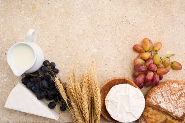 Yahudi bayramı Shavuot konsepti. Tohumlar, süt ve peynir Travertini taşından arka planda.