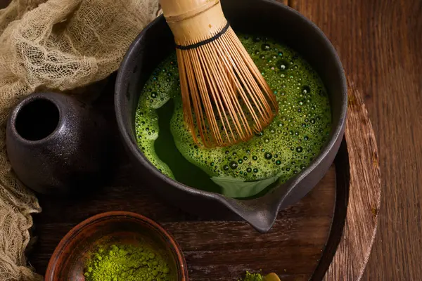 Bir bambu çırpısı canlı yeşil bir kibritin içinde duruyor, sakin ve kırsal bir atmosferi çağrıştırıyor..