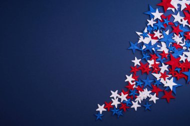 Kırmızı, beyaz ve mavi yıldızlar koyu mavi arkaplandalar..