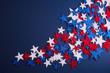 Kırmızı, beyaz ve mavi yıldızlar koyu mavi arkaplana dağılmış neşeli bir atmosfer yaratıyorlar..