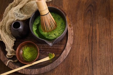 Ahşap zemin üzerinde çırpma ve Japon estetiği olan zarif bir kibrit çay seti..