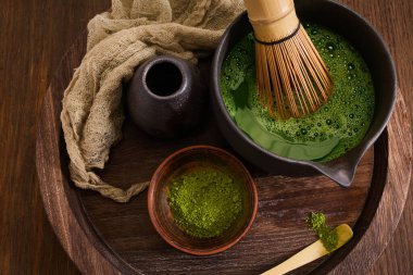 Ahşap zemin üzerinde çırpma ve Japon estetiği olan zarif bir kibrit çay seti..