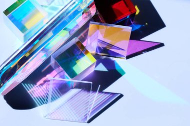 Prismatik şekiller beyaz bir yüzeye canlı, çok renkli gölgeler bırakıyor..