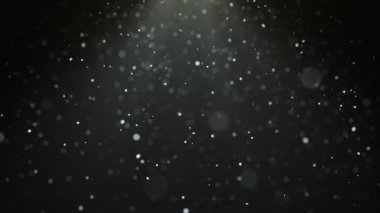 Sahne ışıkları altında siyah arkaplan üzerinde kusursuz döngüsü olan gerçekçi kar yağışı animasyonu. Noel ve tatil tasarımı için kar taneleri bokeh ve kar yağışı.