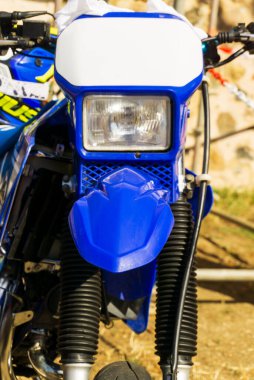 Blue cross motorcycle headlight at the front of the close up