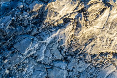 Coastal rocks in the rays of setting sun background