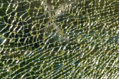 Cracked yellow-green glass background close up