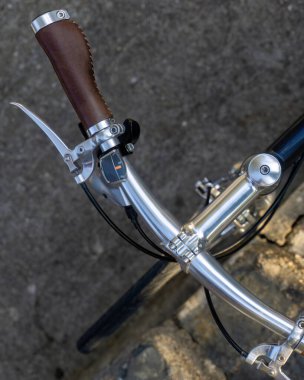 Beautiful dark blue city bike with metallic details and leather saddle and grips in retro style close up