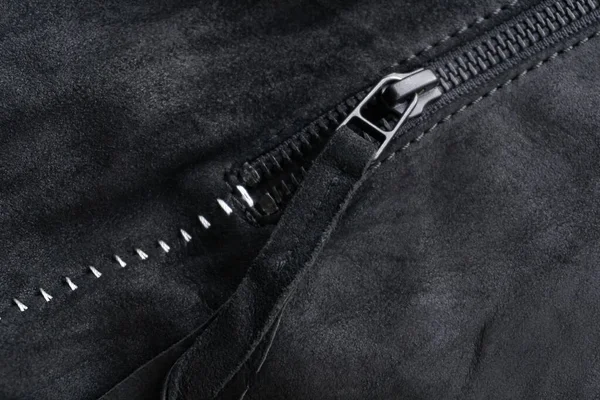 ジップ付きタブ上の黒スエードジャケット白い対照的な縫い目の背景を閉じる — ストック写真