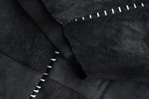 ホワイトコントラストステッチの背景がクローズアップされたブラックスエードジャケットの詳細 — ストック写真