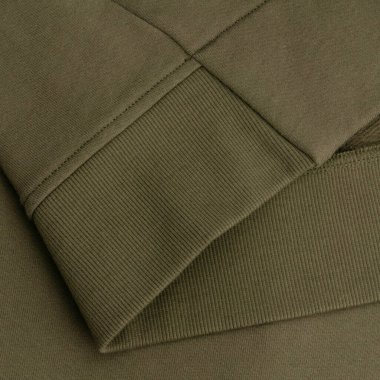 Makro renkli bir eşofman altı kumaşı, yumuşak dokusuna ve tırtıklı kenarına odaklanmış. Bu görüntü, kumaşın karmaşık dokusunu ve elbisenin alt kenarının temiz ve minimal tasarımını yakalar. Yüksek kaliteyi resmetmek için ideal