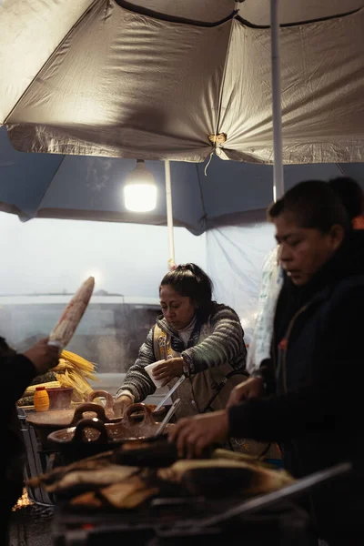 在阴天里卖煮好的玉米和甜点的小贩 — 图库照片