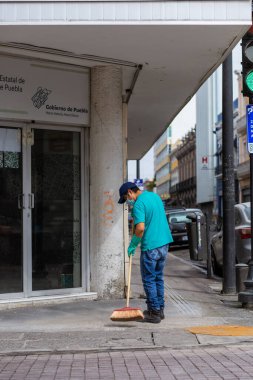 Vatandaşlar, Popocateptl patlaması sırasında 21 Mayıs 'ta meydana gelen Popocateptl' den düşen volkanik kül nedeniyle sokakları tarıyorlar.