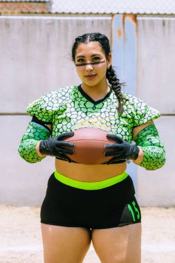 Meksikalı Amerikan futbolcusunun portresi Velociraptor deri desenli üniforma giyiyor.