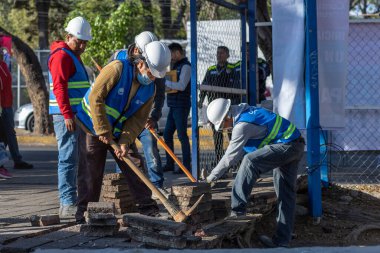 İnşaat işçileri eğlence parkından çimento kaldırıyorlar.