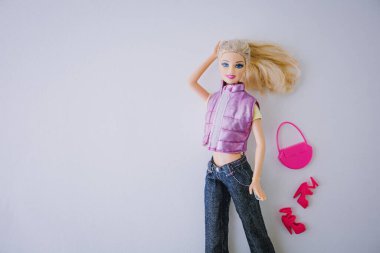 Mor yelek ve kot pantolon giymiş geleneksel bir Barbie bebeğin portresi. Barbie Filmi