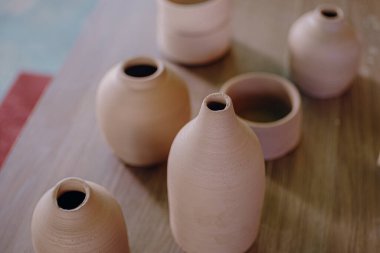 Çağdaş Meksika işçiliğinin detaylarını ve canlı renklerini gösteren kil seramik parçalar bir masada sergilenir..