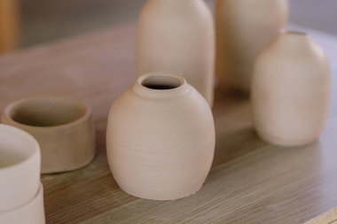 Çağdaş Meksika işçiliğinin detaylarını ve canlı renklerini gösteren kil seramik parçalar bir masada sergilenir..