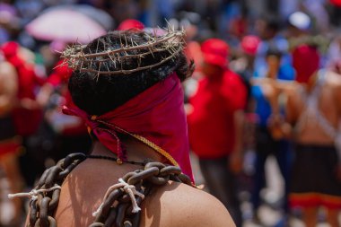 Meksika, Atlixco 'daki Engrillados geleneği sırasında bir adamın kafasının yakın çekimi. Dikenli taç ve kırmızı kaplı yüz inancı, acıyı ve pişmanlığı simgeler..