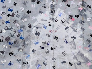 Berlin, Almanya - 6 Temmuz 2022: Üzerinde boyanmış eller olan Berlin duvarı. Elleri mavi, siyah ve kırmızıdır..