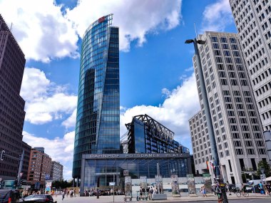 Berlin, Almanya - 4 Temmuz 2022: Postdamer Platz 'daki uzun idari binalar. Ön taraftaki bina yeraltı tren istasyonunun girişi..