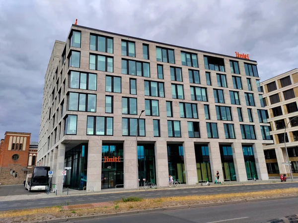 Berlin, Almanya - 6 Temmuz 2022: Gri cepheli ve işlek yolda duran birçok küçük pencereli yeni inşa edilmiş modern otel.