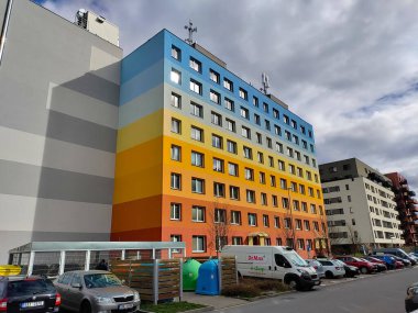 Prag, Çek Cumhuriyeti - 1 Nisan 2023: Gökkuşağı renkli yüzlü eski komünist tarzı apartman blokları. Ön taraftaki cadde araba dolu..