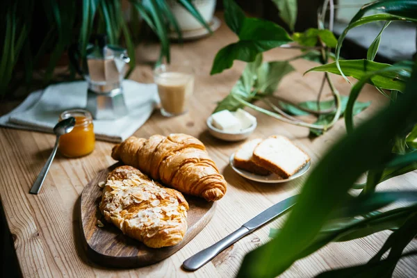 Sarapan Dengan Croissant Dan Kopi Disajikan Meja Indah Penuh Tanaman — Stok Foto