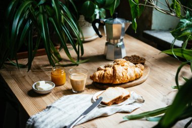 Çöreklerle kahvaltı ve bitki dolu güzel bir masada servis edilen kahve. Ev kavramının tadını çıkarıyorum..