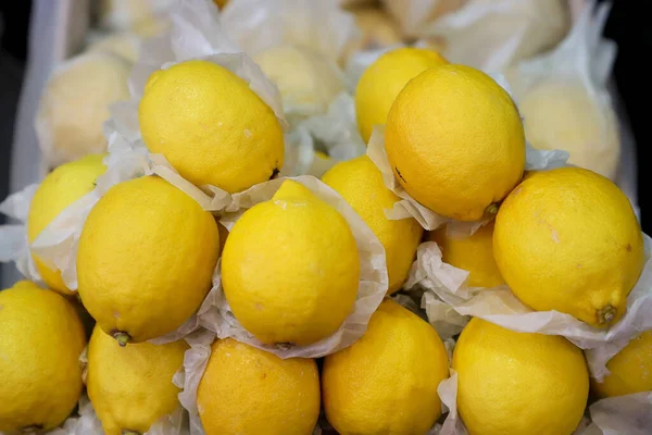 Fresh lemons for sale in a grocery store setting.