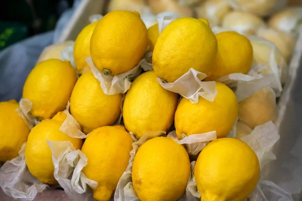 Fresh lemons for sale in a grocery store setting.