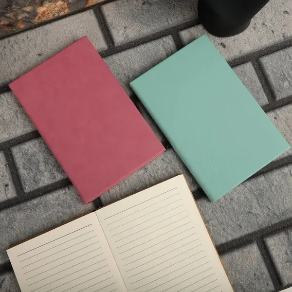 Leather Journals and Notebooks in pink and teal colors. Concept shot, top view. Custom background Journals and Notebooks view. Leather Sketchbook. Space Blank for text