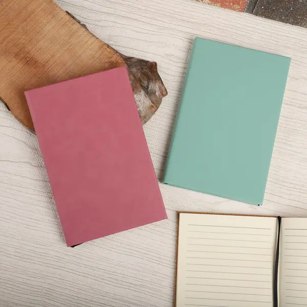 Leather Journals and Notebooks in teal and pink colors. Concept shot, top view. Custom background Journals and Notebooks view. Leather Sketchbook. Space Blank for text