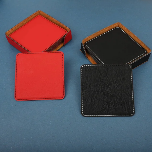 Leather table mats in different colors. Concept shot, top view. Custom background view of leather table coaster. Stitched and leather table coaster. Beverage coaster.