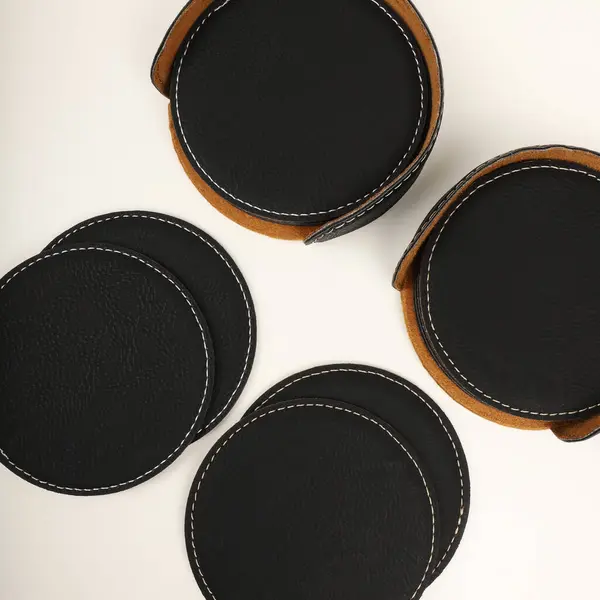Leather table mats in black colors. Concept shot, top view. Custom background view of leather table coaster. Stitched and leather table coaster