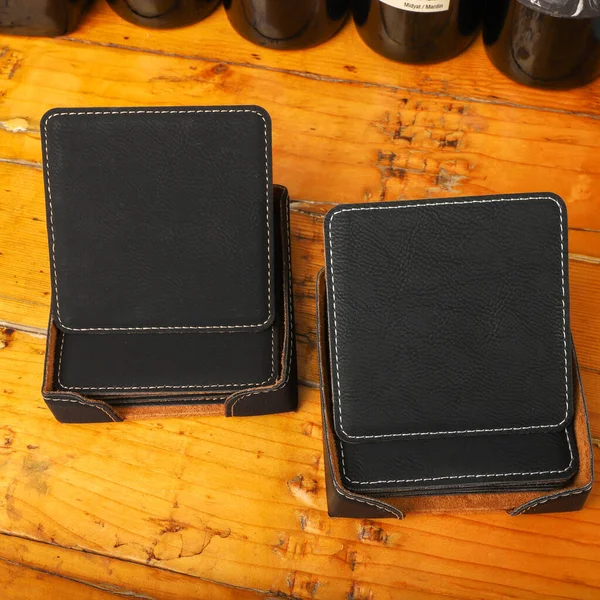 Leather table mats in black colors. Concept shot, top view. Custom background view of leather table coaster. Stitched and leather table coaster
